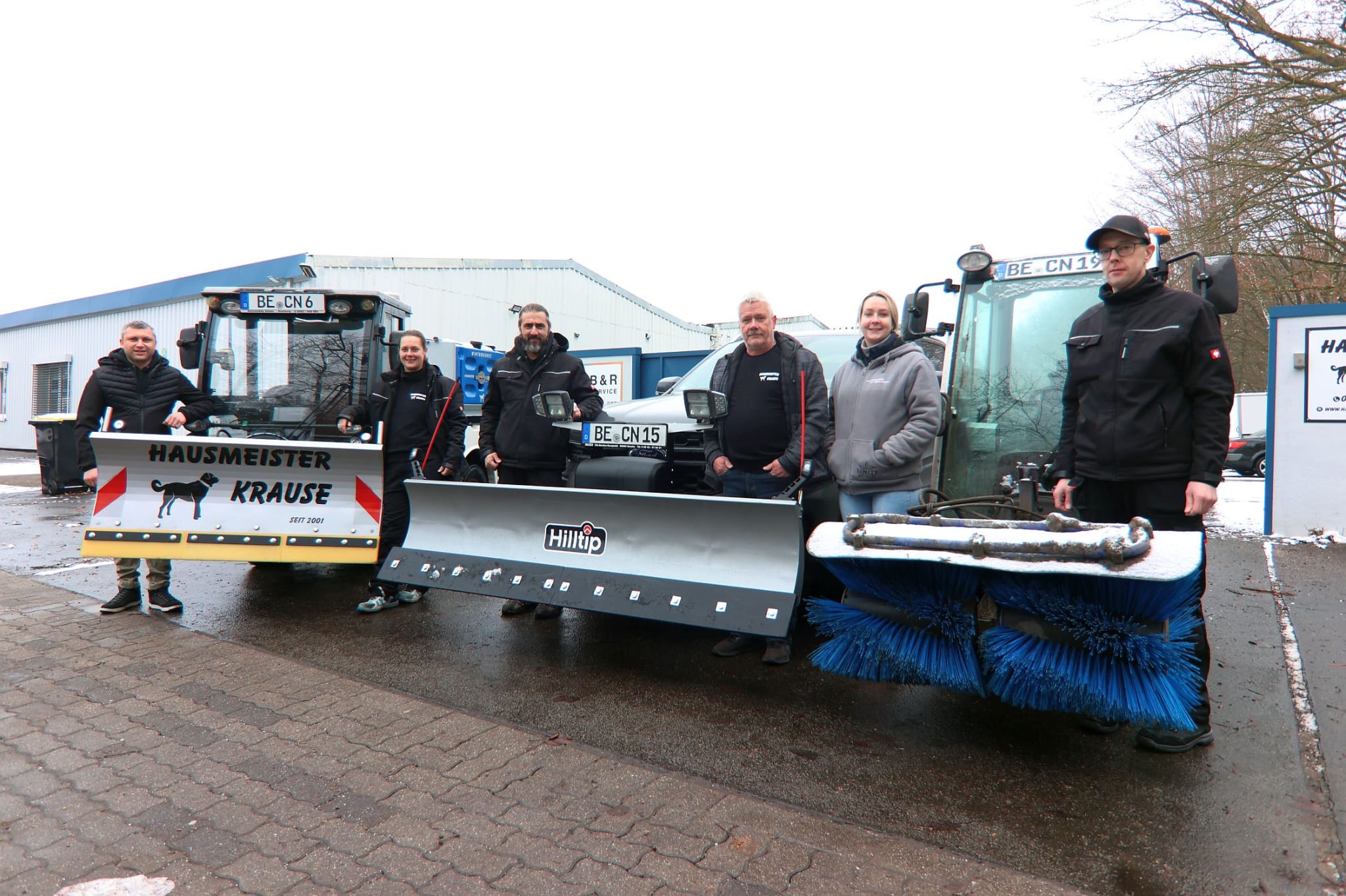 Das Team von Hausmeister Krause mit Fahrzeugen und Winterdiensttechnik am Standort in Ahlen